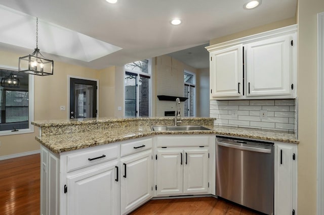 kitchen with white cabinetry, sink, stainless steel dishwasher, and kitchen peninsula