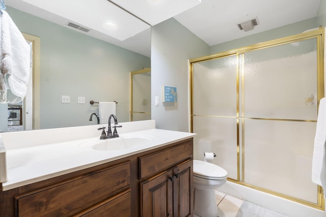 bathroom with an enclosed shower, vanity, tile patterned floors, and toilet