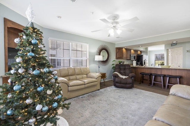 carpeted living room featuring ceiling fan