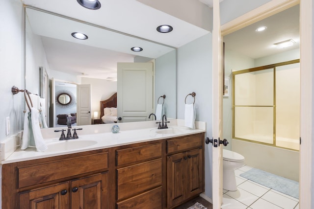 full bathroom featuring bath / shower combo with glass door, vanity, tile patterned floors, and toilet