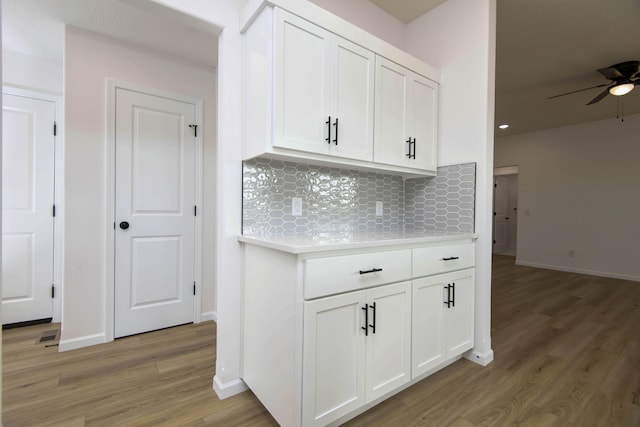 kitchen featuring tasteful backsplash, ceiling fan, light hardwood / wood-style flooring, and white cabinets