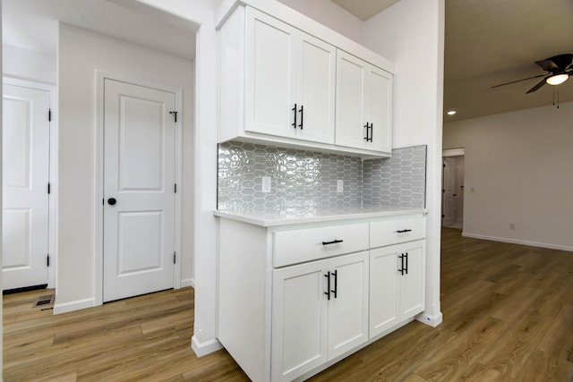 kitchen with backsplash, ceiling fan, light hardwood / wood-style floors, and white cabinets