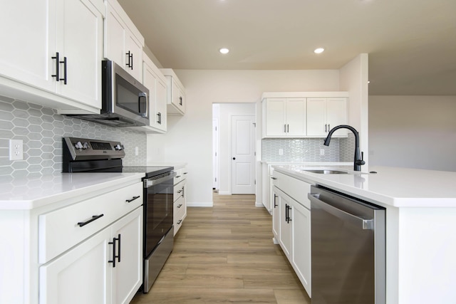 kitchen with appliances with stainless steel finishes, sink, and white cabinets