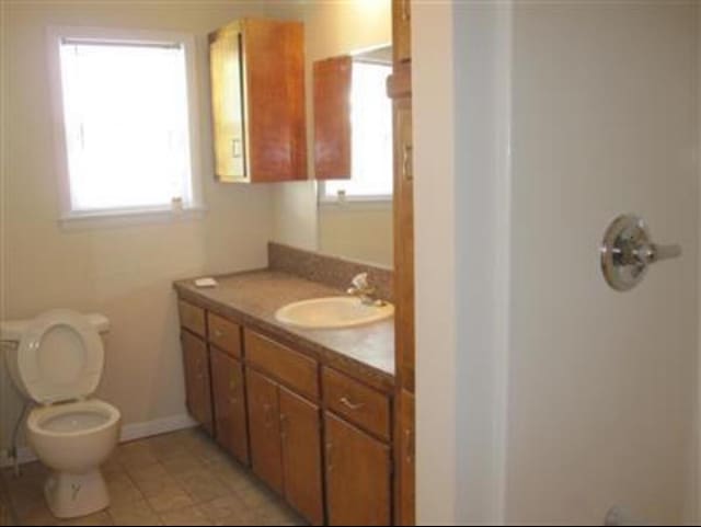 bathroom featuring vanity, a healthy amount of sunlight, and toilet