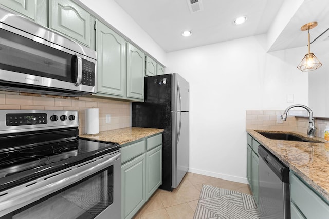 kitchen featuring sink, light tile patterned floors, appliances with stainless steel finishes, light stone countertops, and backsplash