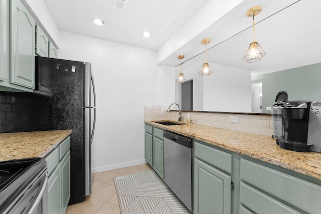 kitchen with light stone counters, sink, decorative backsplash, and appliances with stainless steel finishes