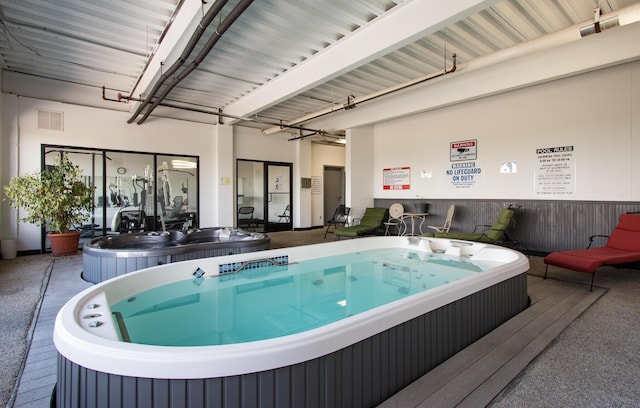 view of swimming pool with an indoor hot tub