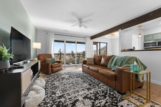 living room featuring beamed ceiling, ceiling fan, and hardwood / wood-style floors