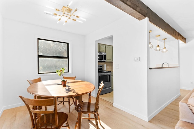 dining space with beam ceiling, an inviting chandelier, and light hardwood / wood-style floors