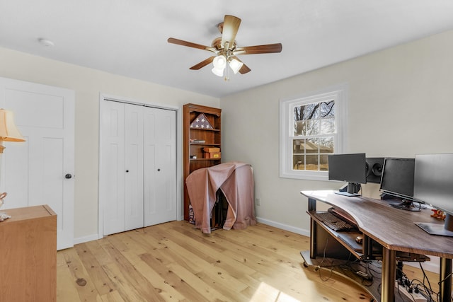 home office with ceiling fan and light hardwood / wood-style flooring