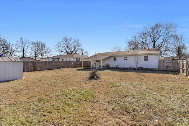 rear view of house with a storage unit and a lawn