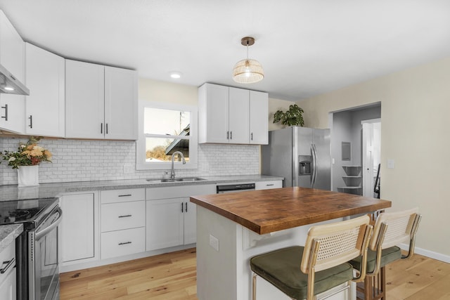 kitchen featuring sink, hanging light fixtures, appliances with stainless steel finishes, a kitchen island, and white cabinets