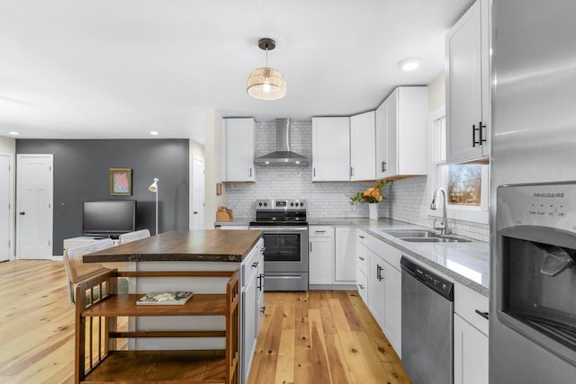 kitchen featuring white cabinetry, appliances with stainless steel finishes, sink, and wall chimney range hood