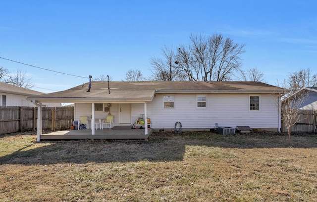 back of property with a wooden deck, a yard, and central AC