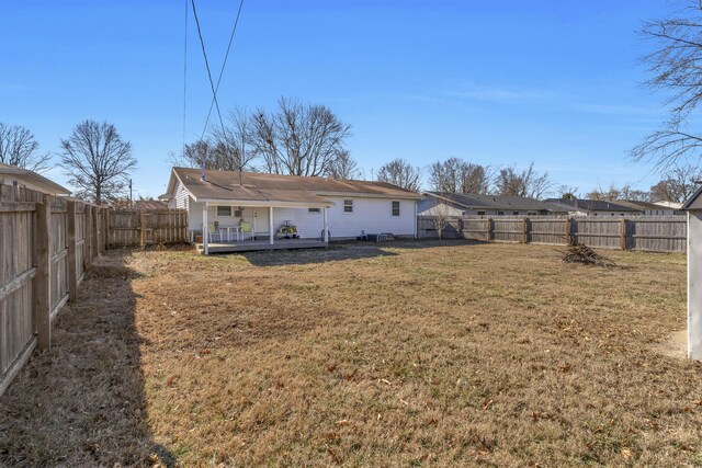 back of property with a wooden deck and a yard