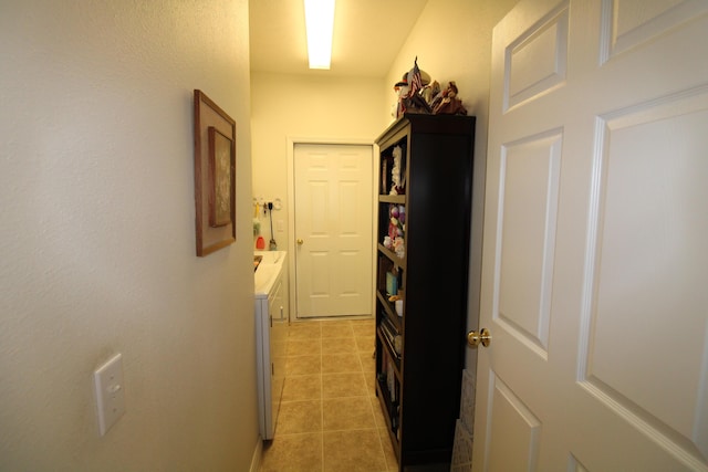 corridor with independent washer and dryer and light tile patterned flooring