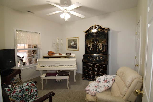 living area featuring carpet floors and ceiling fan