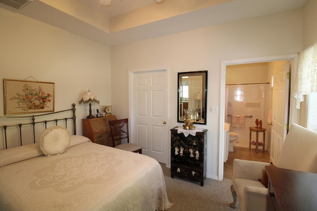 bedroom featuring ensuite bath and carpet