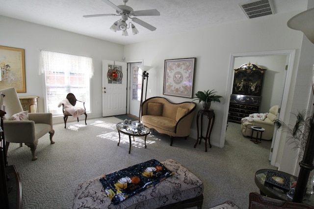 living room with a textured ceiling, light colored carpet, and ceiling fan