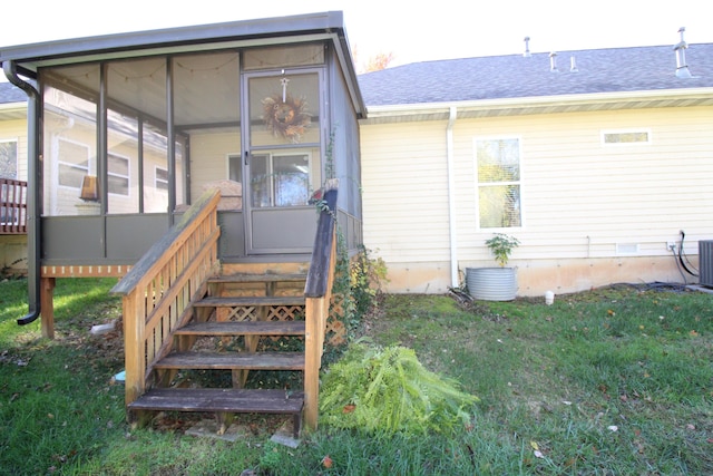 rear view of property with a sunroom and a lawn