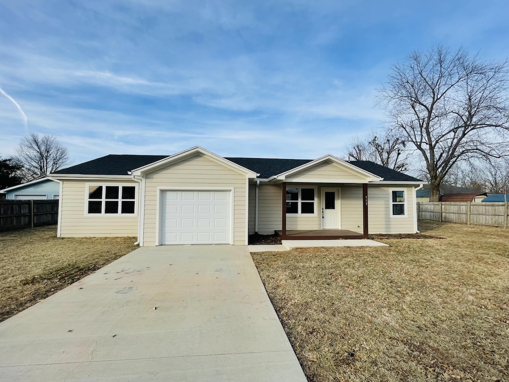 single story home with a garage, a front lawn, and a porch