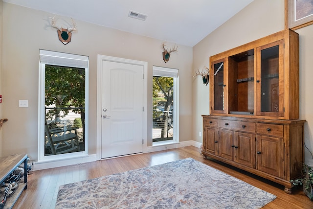 foyer entrance featuring vaulted ceiling and light hardwood / wood-style floors