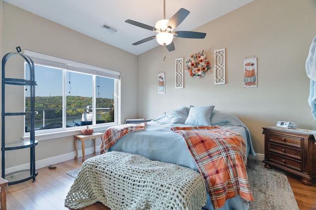 bedroom with ceiling fan, light hardwood / wood-style floors, and multiple windows