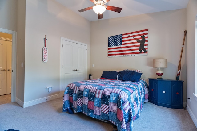 bedroom with ceiling fan, light colored carpet, and a closet