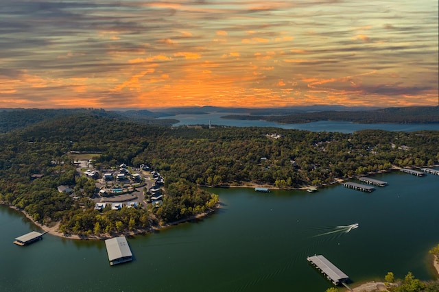 aerial view at dusk featuring a water view