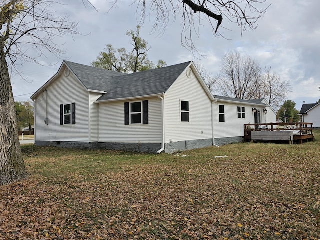 view of side of home featuring a wooden deck and a lawn