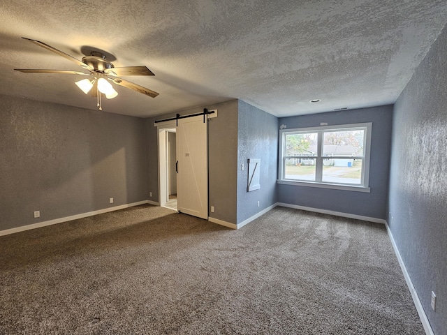 1101 E 18th St, Lamar, MO 64759 - unfurnished bedroom with ceiling fan, carpet flooring, a barn door, and a textured ceiling