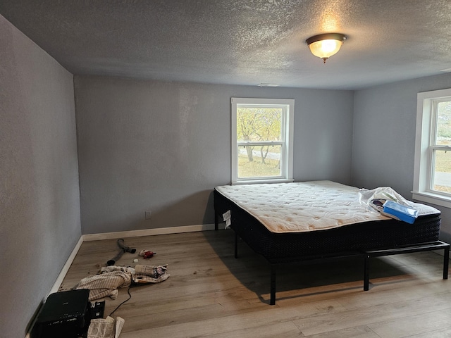 1101 E 18th St, Lamar, MO 64759 - bedroom with light hardwood / wood-style floors and a textured ceiling