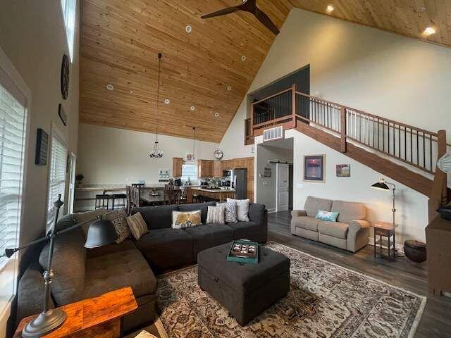 living room featuring a wealth of natural light, high vaulted ceiling, and wood finished floors