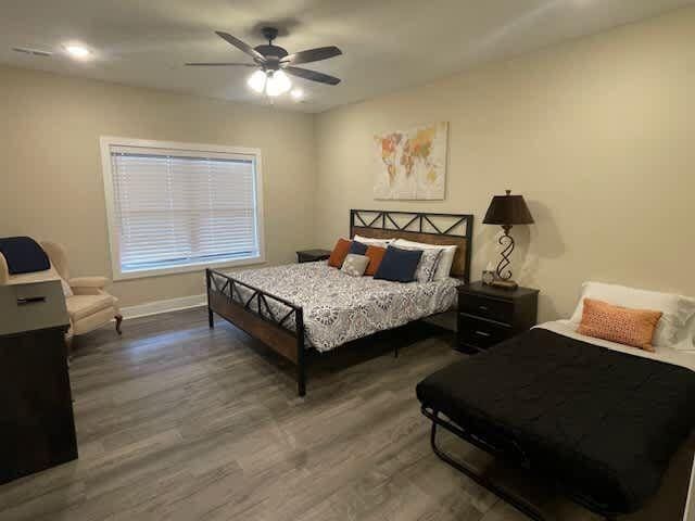 bedroom featuring a ceiling fan, baseboards, and wood finished floors