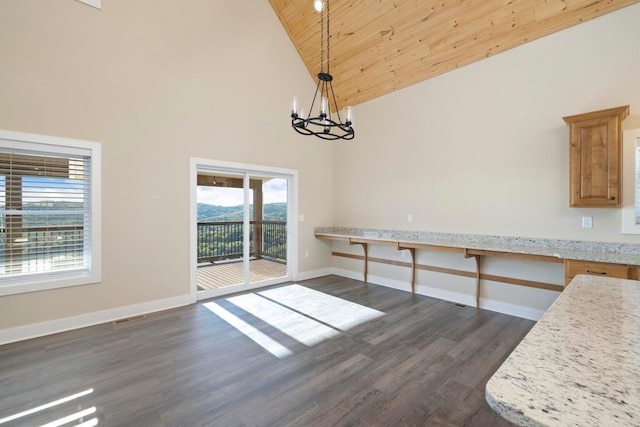 unfurnished dining area with visible vents, baseboards, an inviting chandelier, and dark wood-style floors