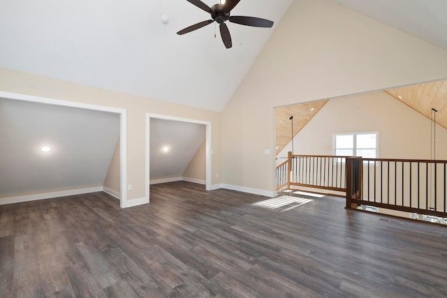 interior space with ceiling fan, baseboards, high vaulted ceiling, and wood finished floors