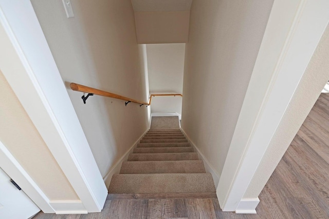 staircase with baseboards and wood finished floors