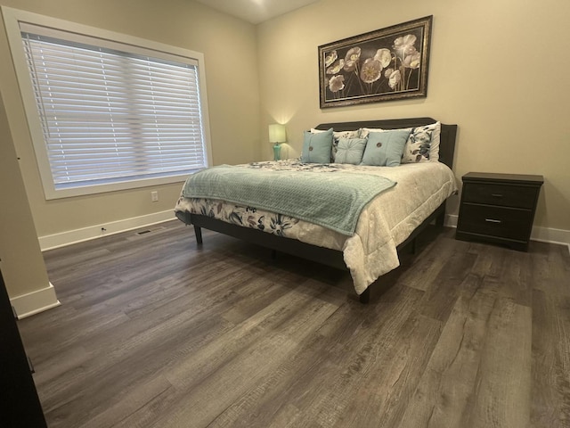 bedroom with dark wood-style floors and baseboards