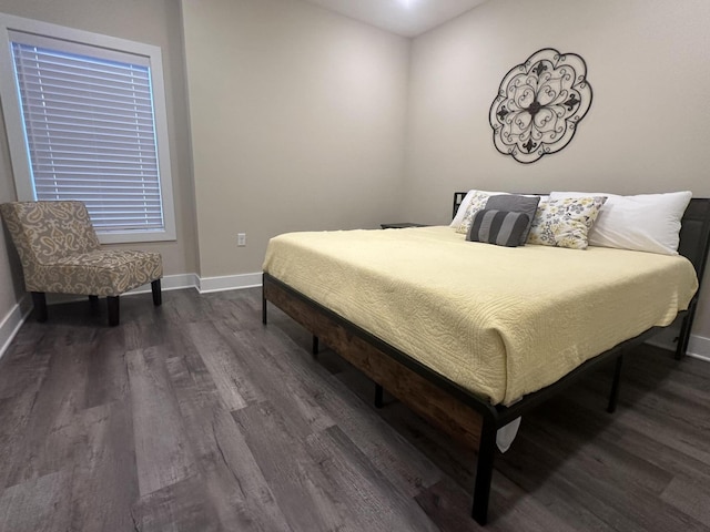 bedroom with baseboards and wood finished floors