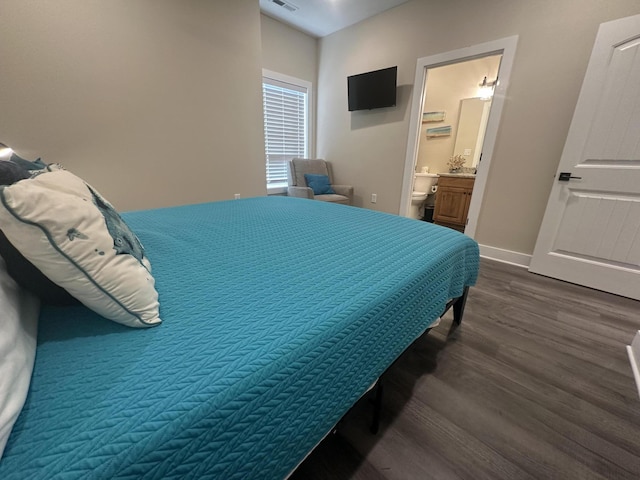 bedroom featuring dark wood finished floors, visible vents, ensuite bathroom, and baseboards