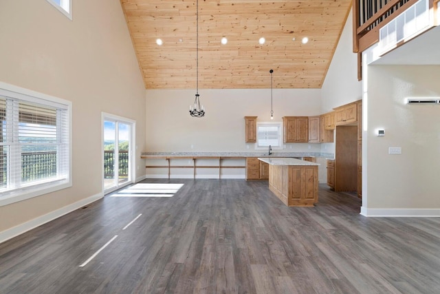 kitchen featuring baseboards, a kitchen island, and dark wood-style floors