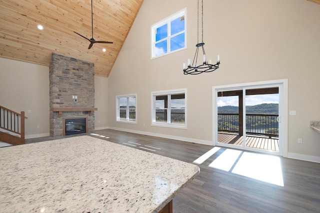 unfurnished living room with dark wood-type flooring, wood ceiling, a fireplace, and baseboards