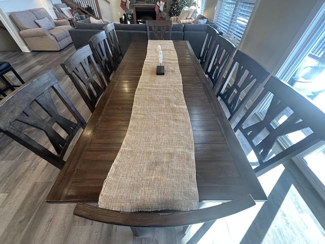 dining room featuring a stone fireplace and wood finished floors