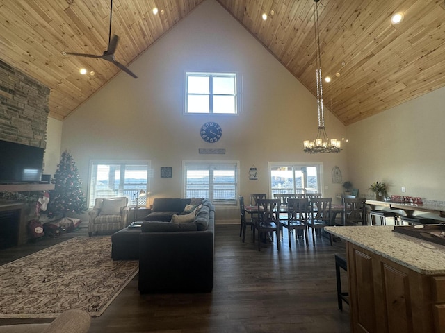 living room with a stone fireplace, dark wood-type flooring, and wood ceiling