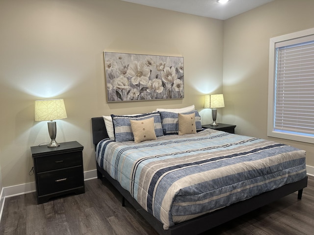 bedroom with baseboards and wood finished floors