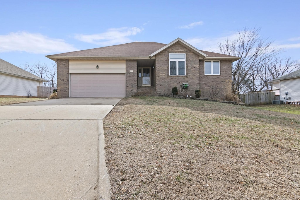 ranch-style home with a garage and a front yard