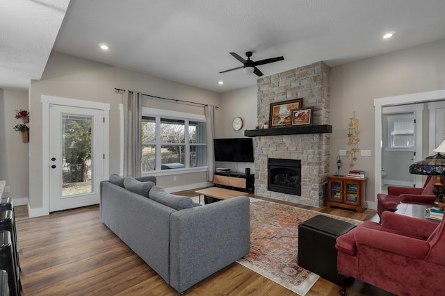 living room featuring ceiling fan, a fireplace, and hardwood / wood-style floors