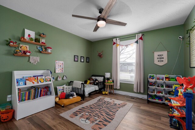 bedroom with hardwood / wood-style flooring, ceiling fan, and a textured ceiling