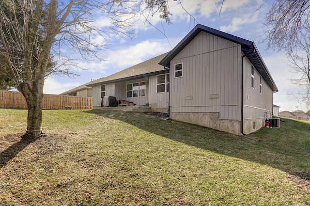 rear view of house featuring a yard and central air condition unit