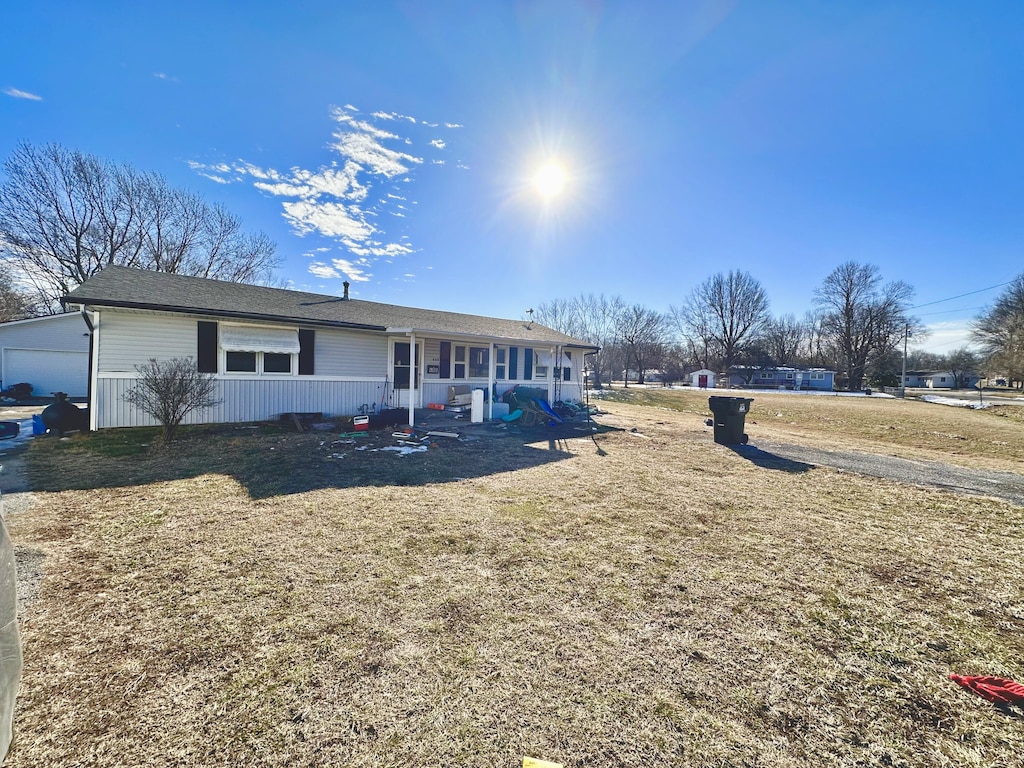 single story home with a porch and a front lawn